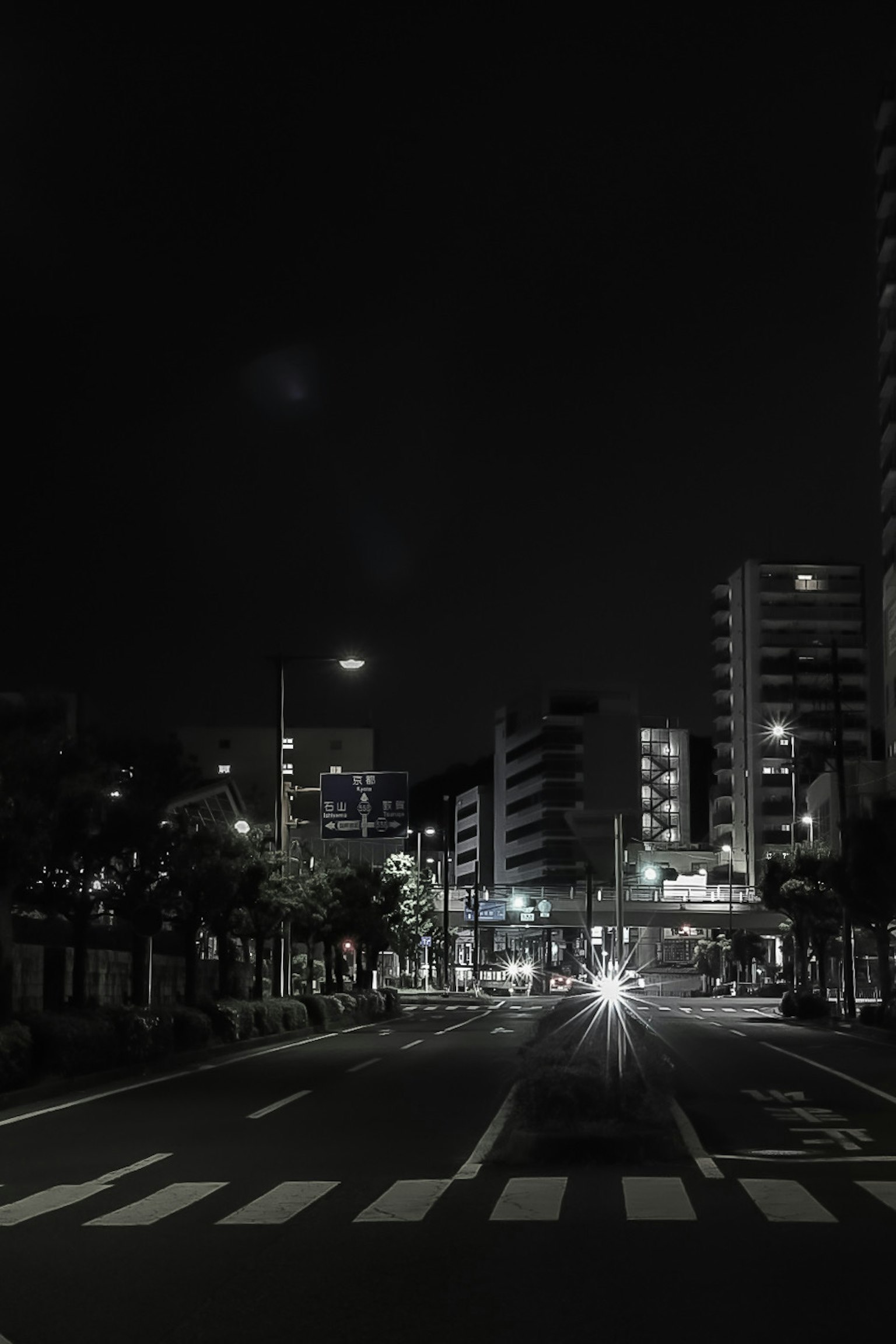 Nächtliche Stadtlandschaft mit einem Zebrastreifen und Gebäuden