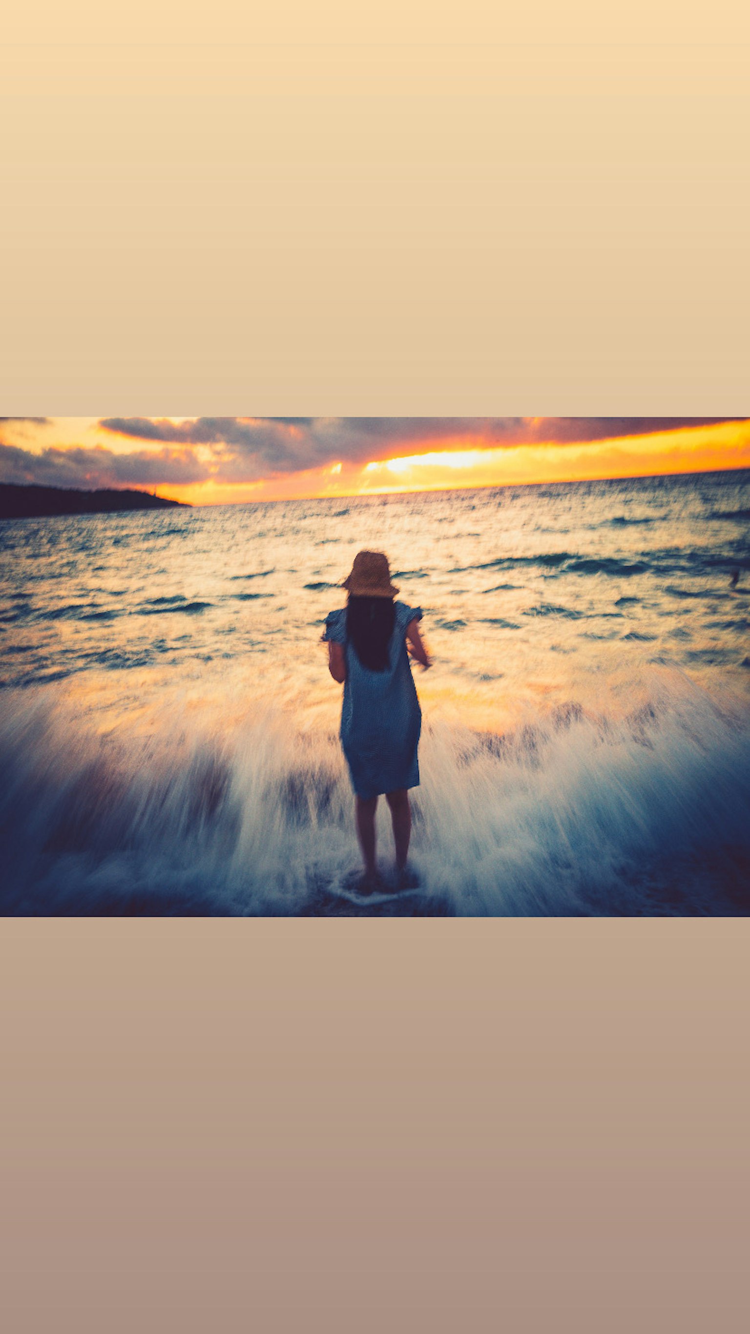 夕阳下站在海里的女性轮廓海浪拍打