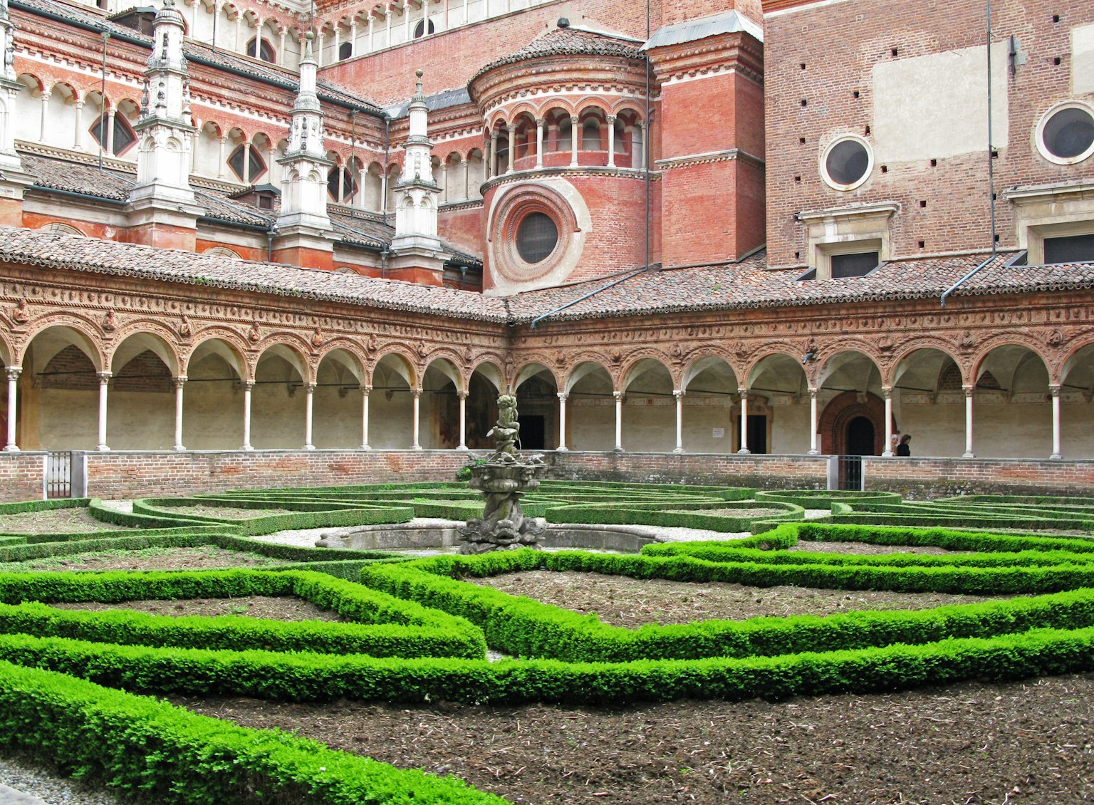 Jardin de cour magnifique avec des haies et des colonnades arquées