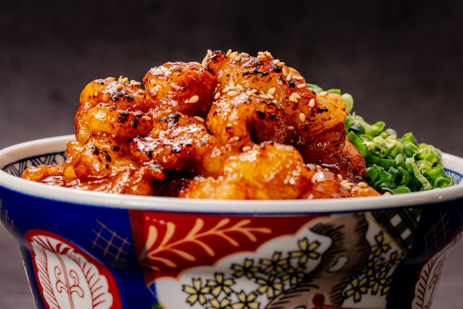 美味的虾菜肴盛在色彩丰富的碗中，上面撒有芝麻和葱