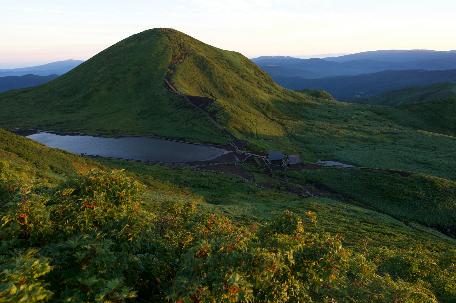 Üppige grüne Berglandschaft mit einem ruhigen See
