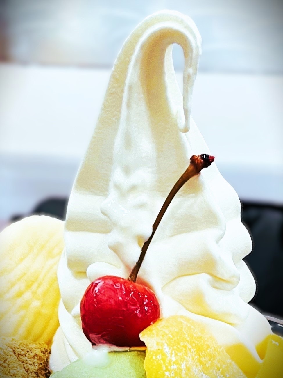 white soft-serve ice cream with cherry and fruit toppings