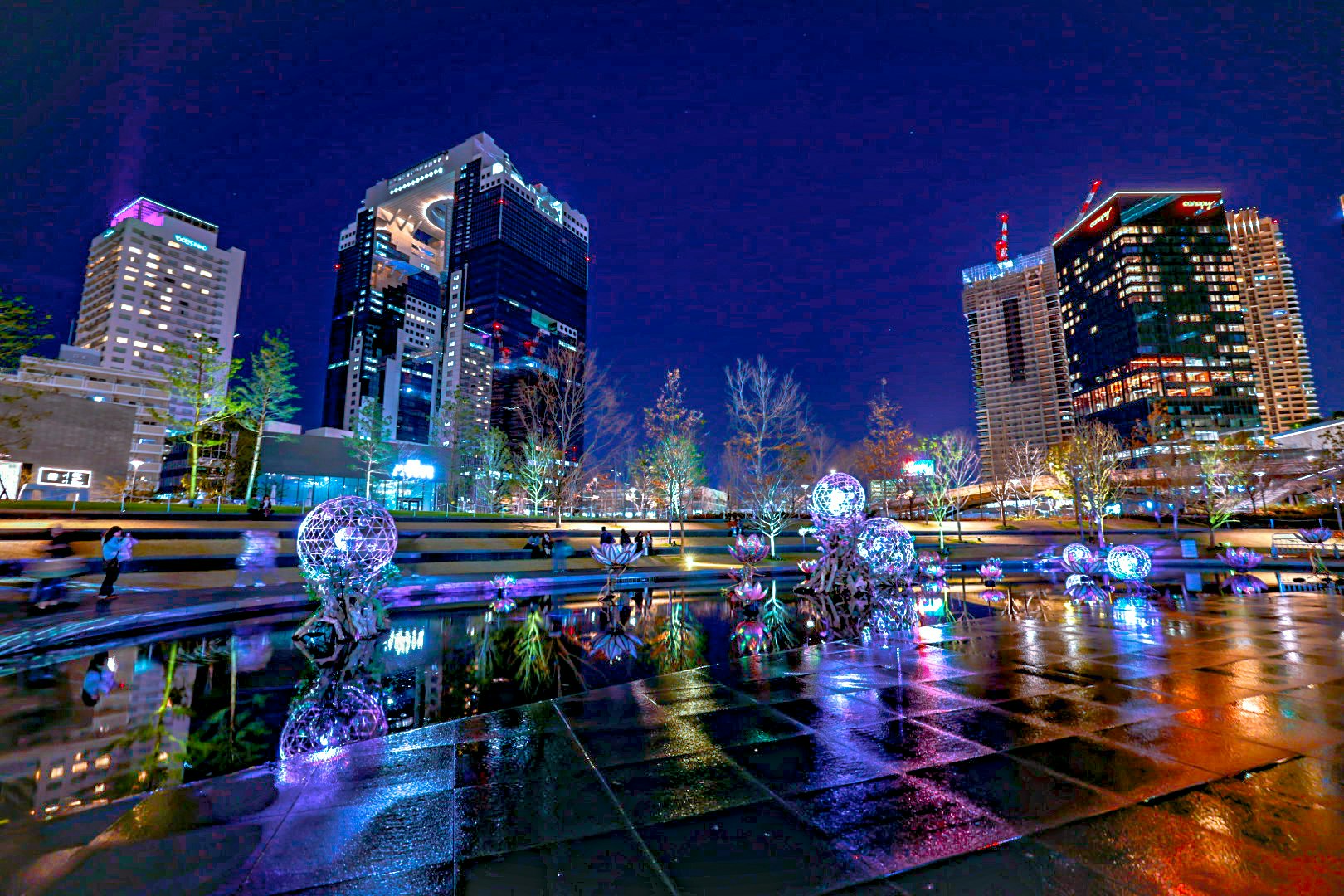 skyline nocturne de gratte-ciels et promenade au bord de l’eau illuminée