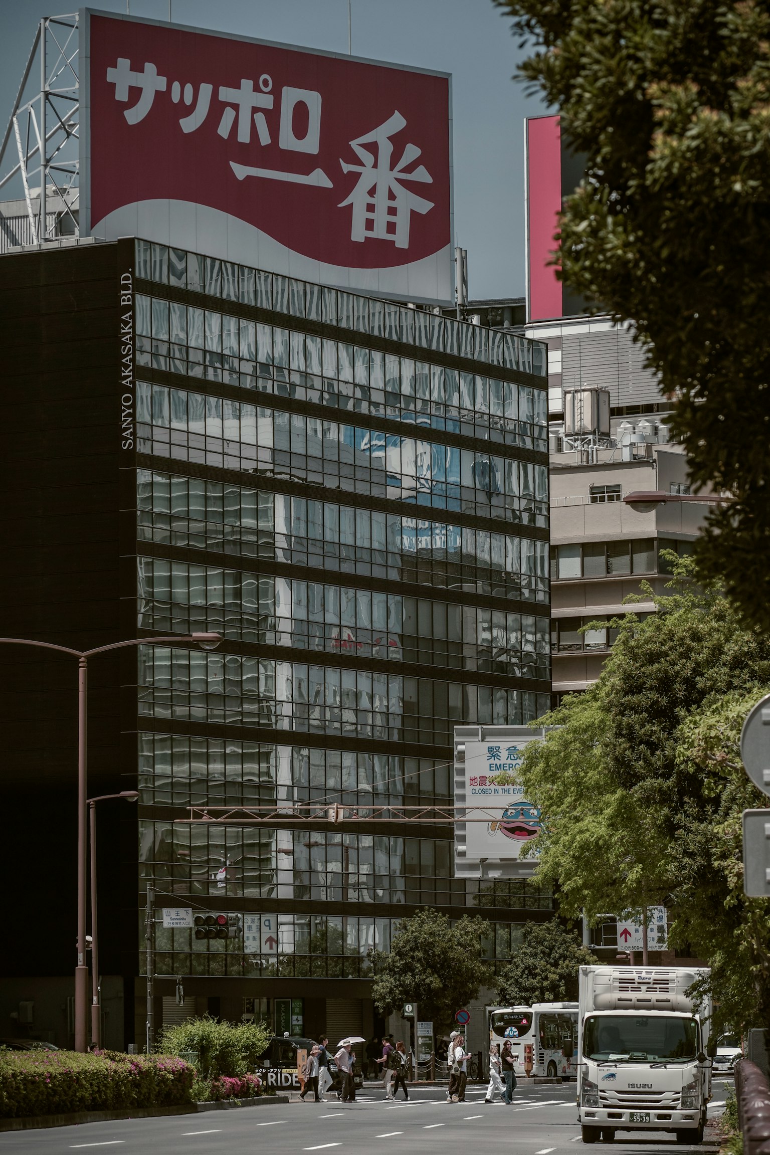 Bangunan modern dengan iklan Sapporo di pemandangan jalan Tokyo