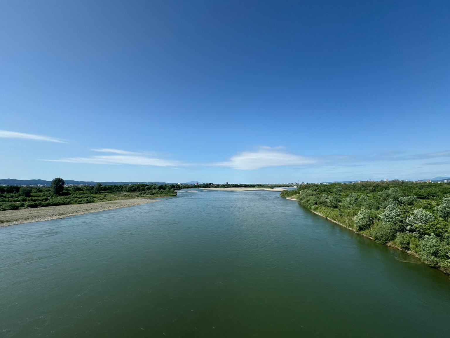 Paysage de rivière serein avec une végétation luxuriante et un ciel bleu clair