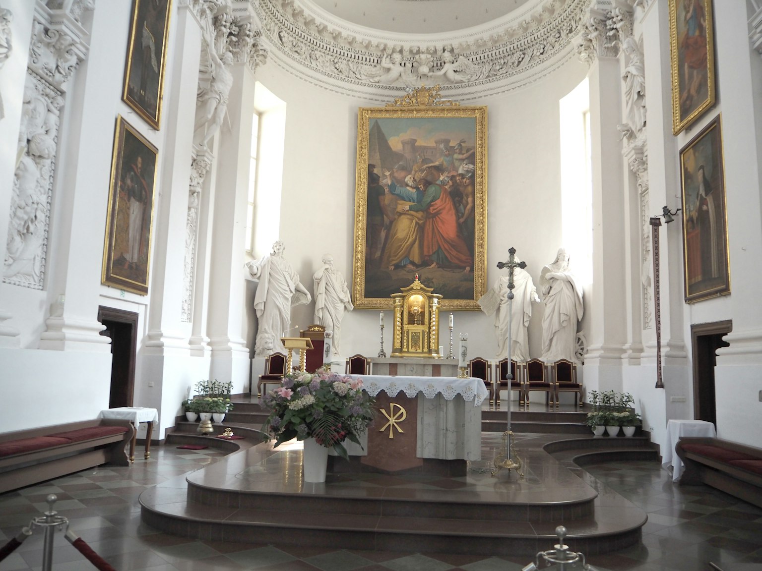 Intérieur d'une église avec un autel orné et une grande peinture