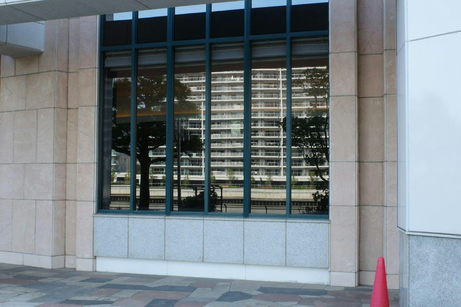 Reflejo de ventana de edificio y pared exterior de azulejos