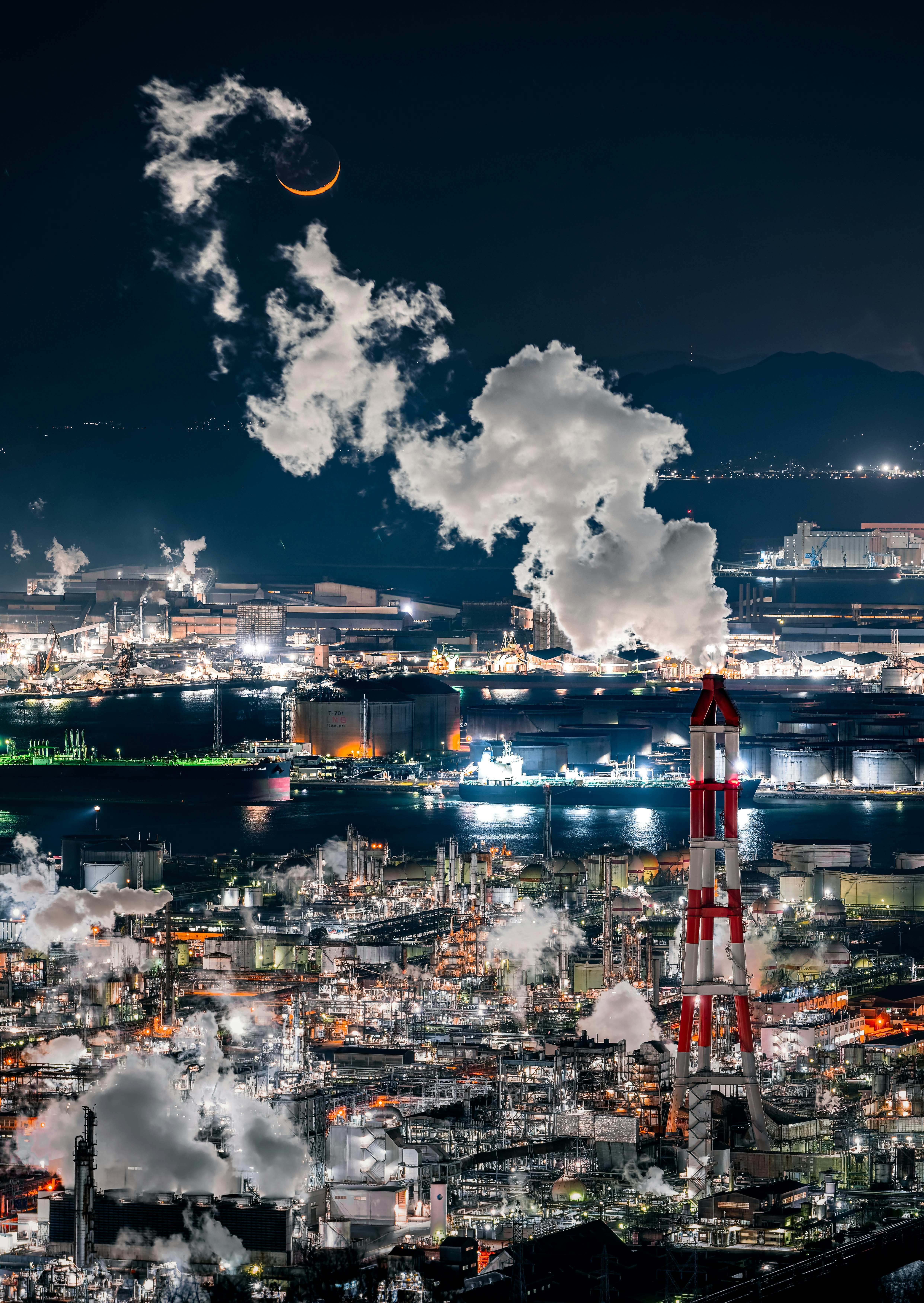 夕景の工業地帯と煙突から立ち上る白煙