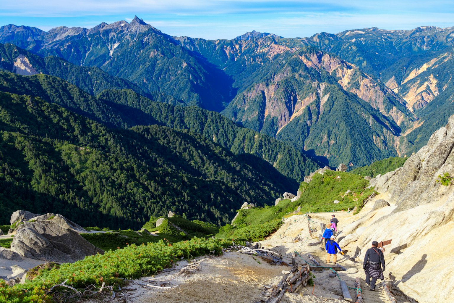 Pemandangan hiking dengan gunung dan lembah subur di latar belakang