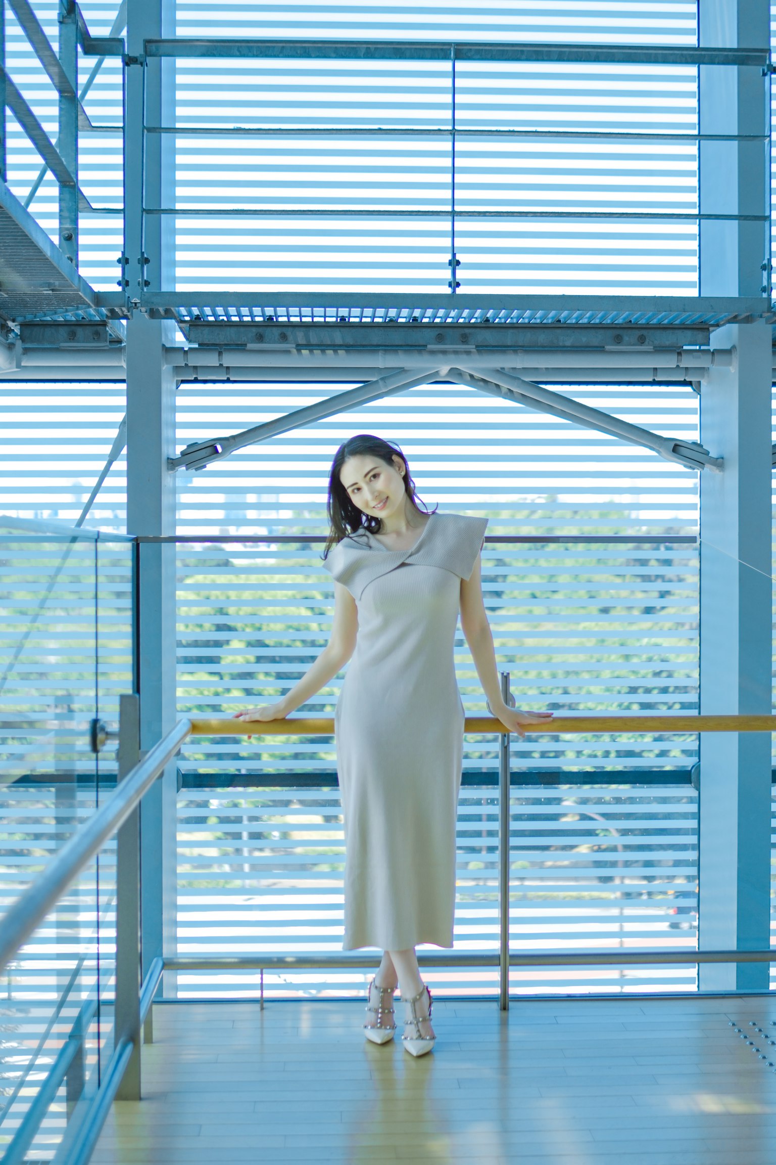 一位女性站在一座帶有藍色元素的現代建築中
