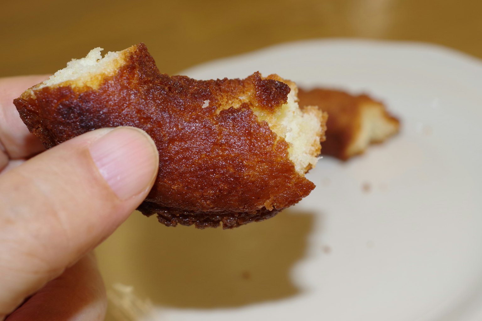 Un trozo mordido de un dulce sostenido en una mano