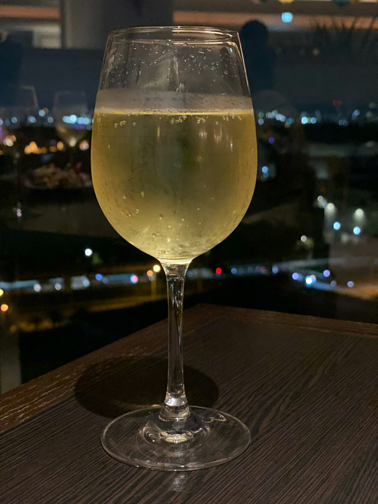背景為城市天際線的起泡白葡萄酒杯