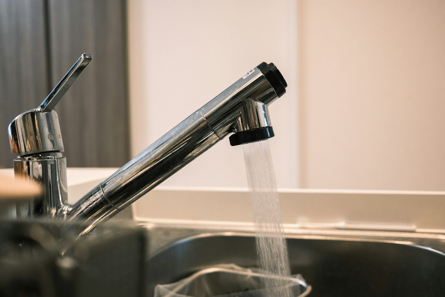 A kitchen faucet with water flowing from it