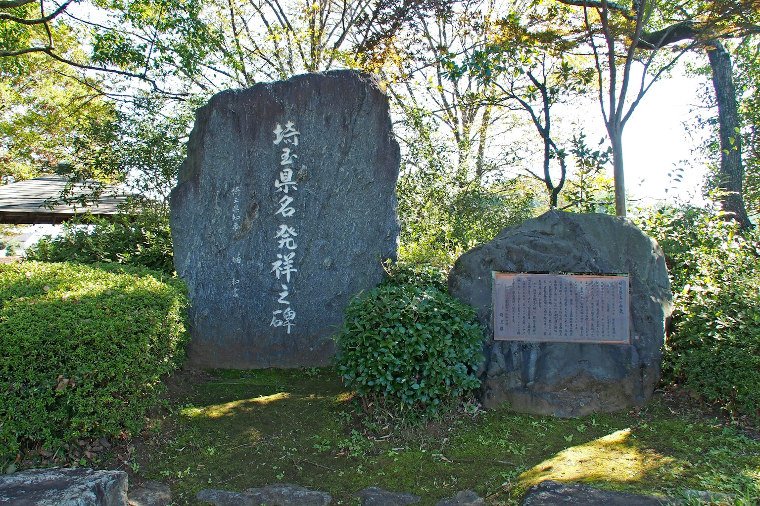Scène de parc avec un monument en pierre et une plaque d'information