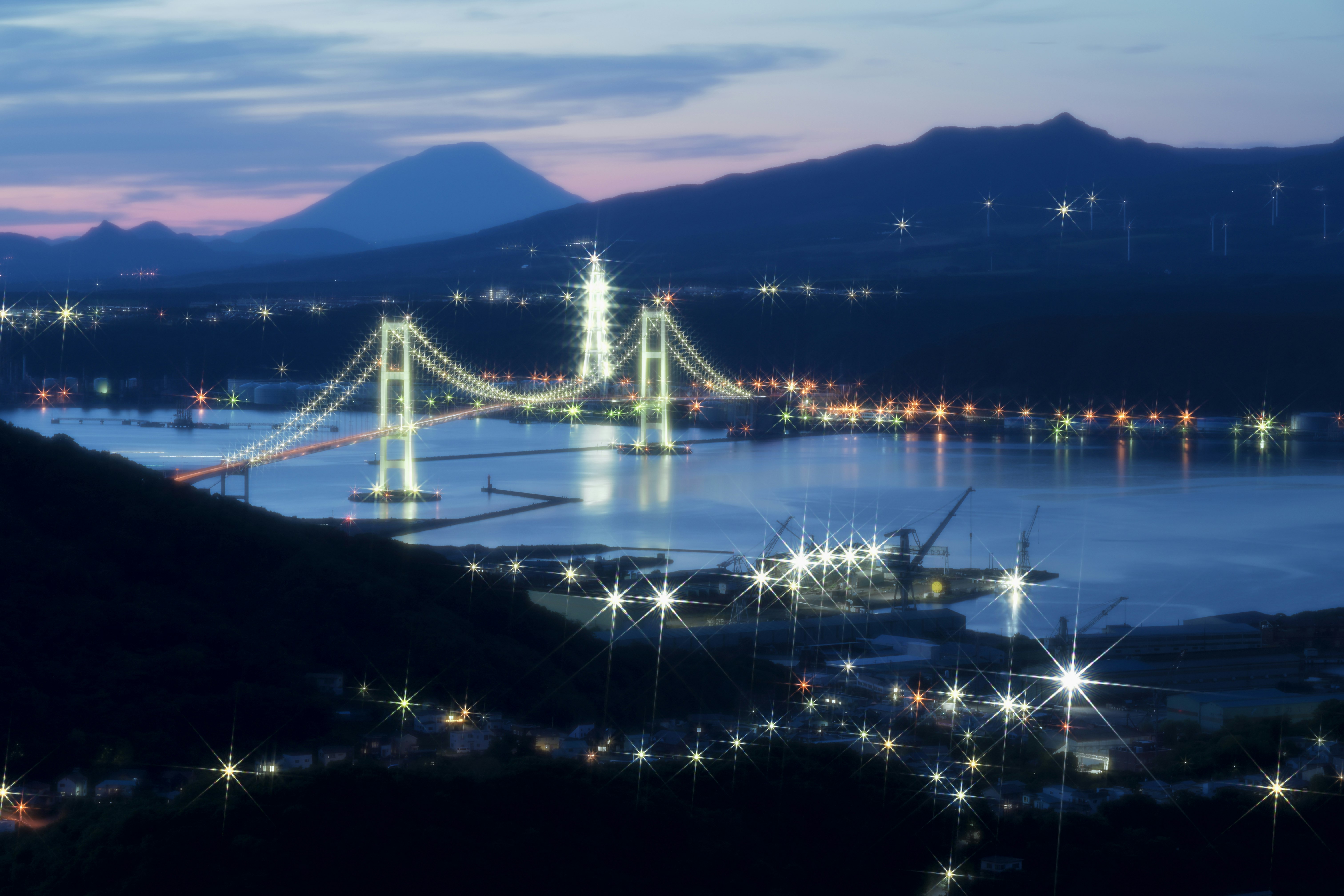 夜景のライトアップされた海と橋、室蘭の街並みと山