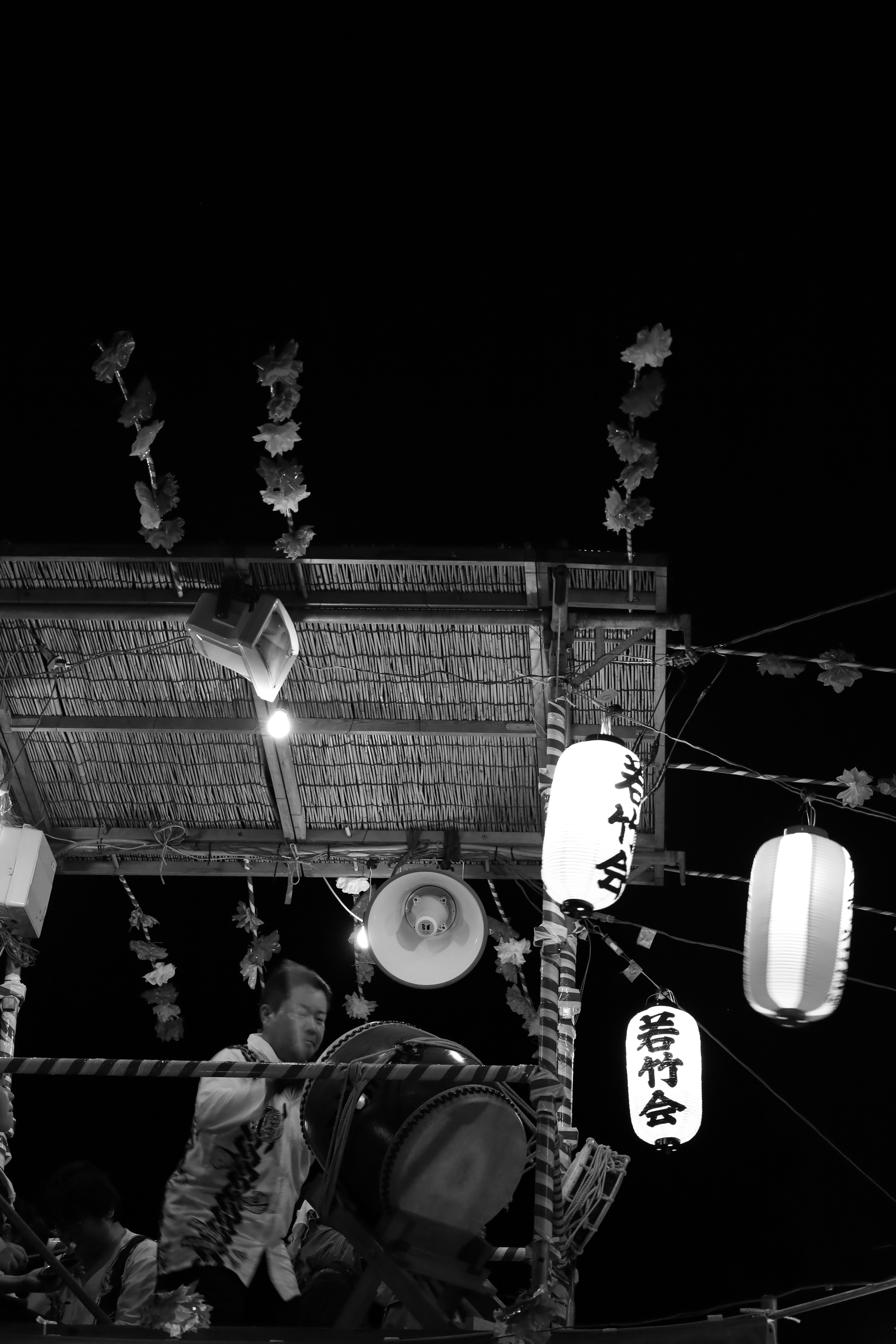 太鼓とやぐらがある夏祭りの夜の屋台周辺