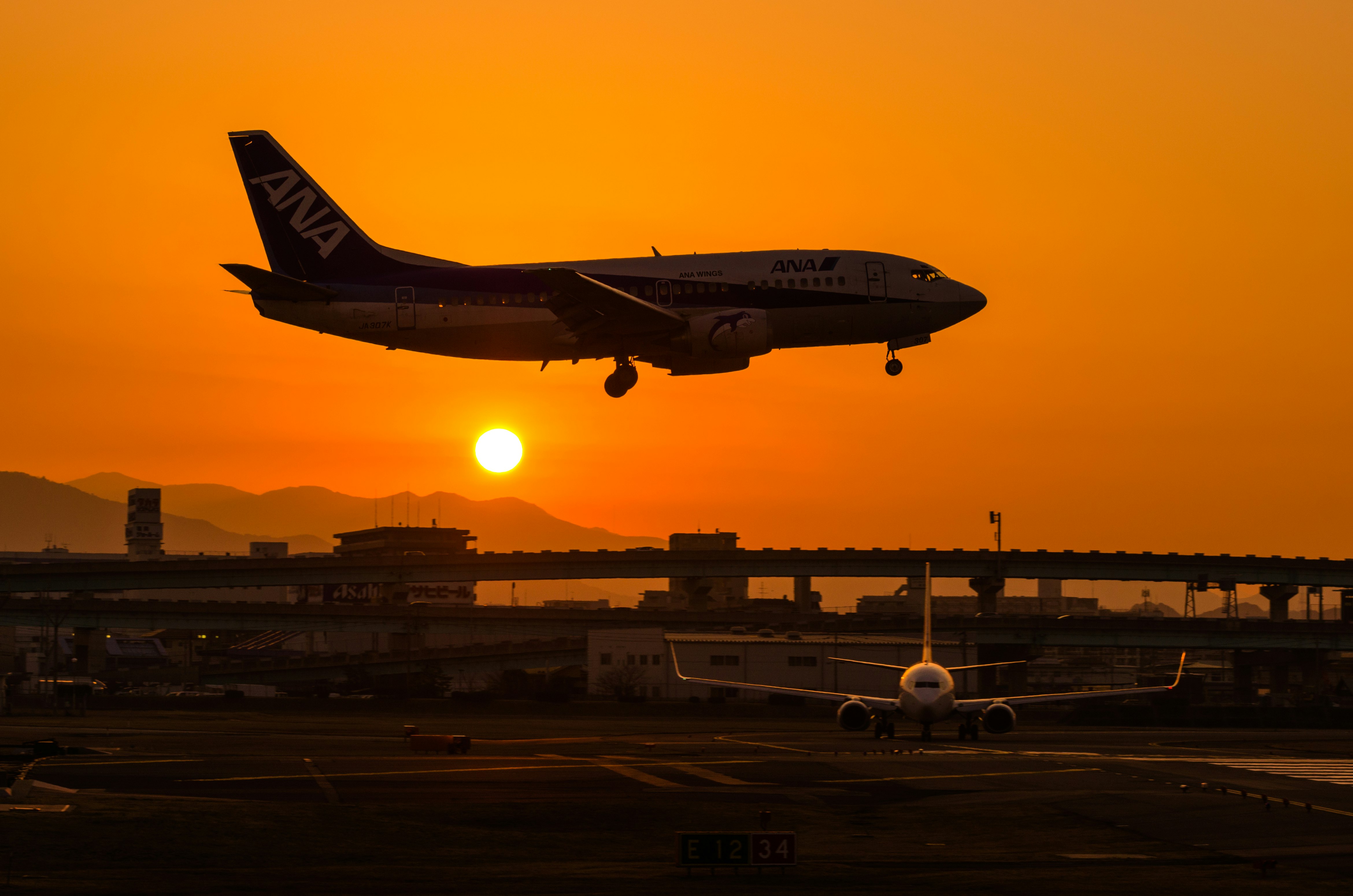 夕日に照らされる福岡空港のANA機と滑走路