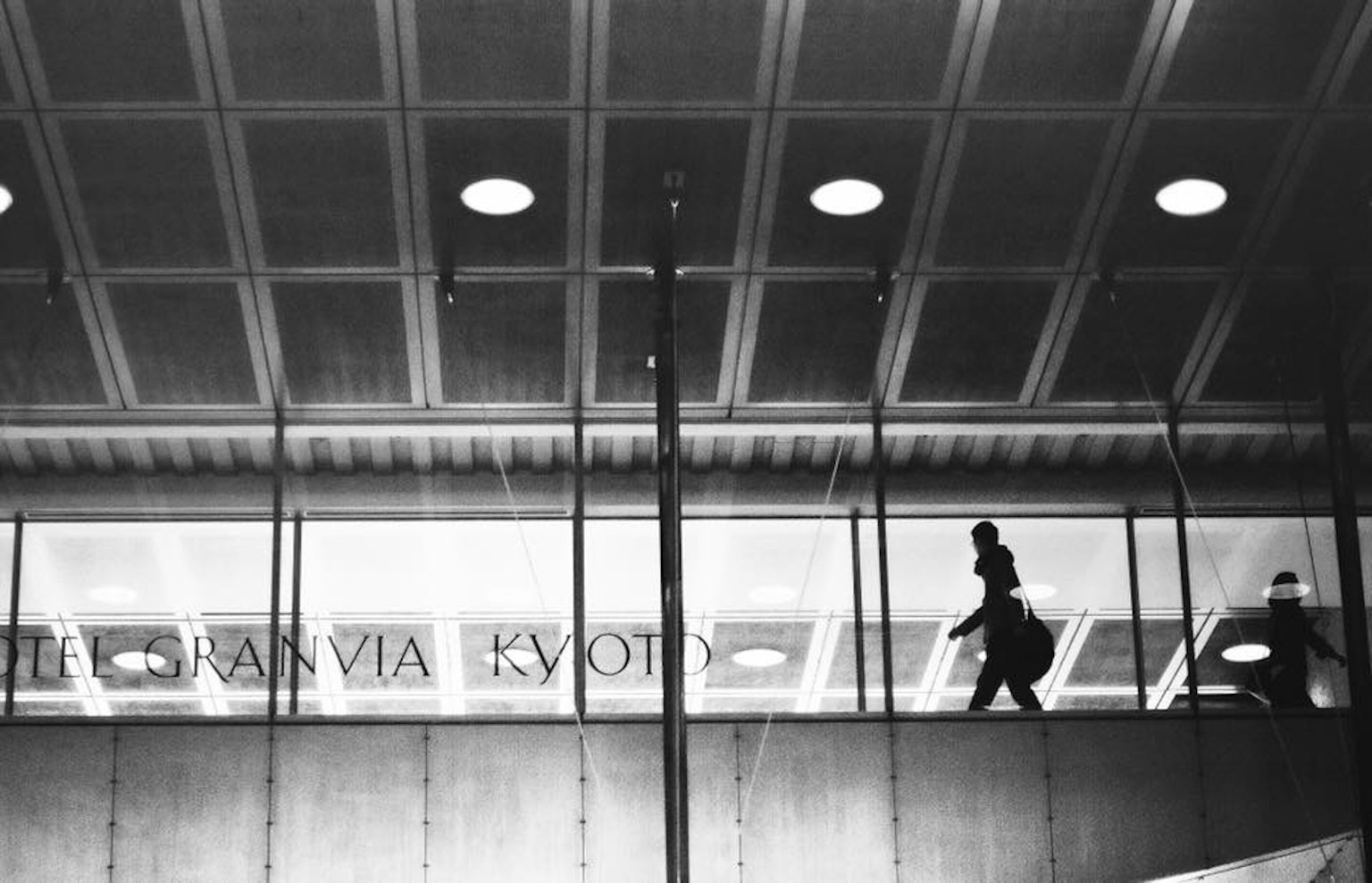 Silhouette di una persona che cammina in un edificio moderno alla stazione di Kyoto