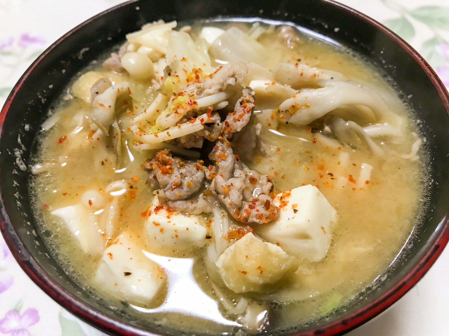 Warme Suppe mit verschiedenen Zutaten in Miso-Brühe