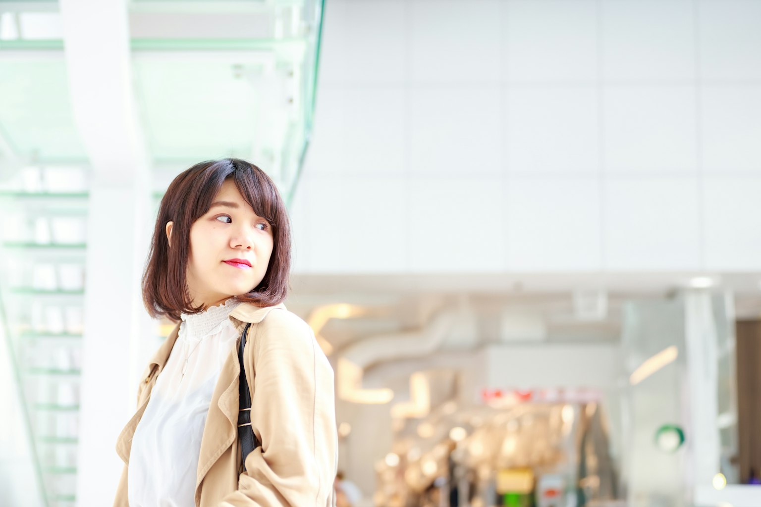 ผู้หญิงยิ้มอยู่หน้ากำแพงสีขาว