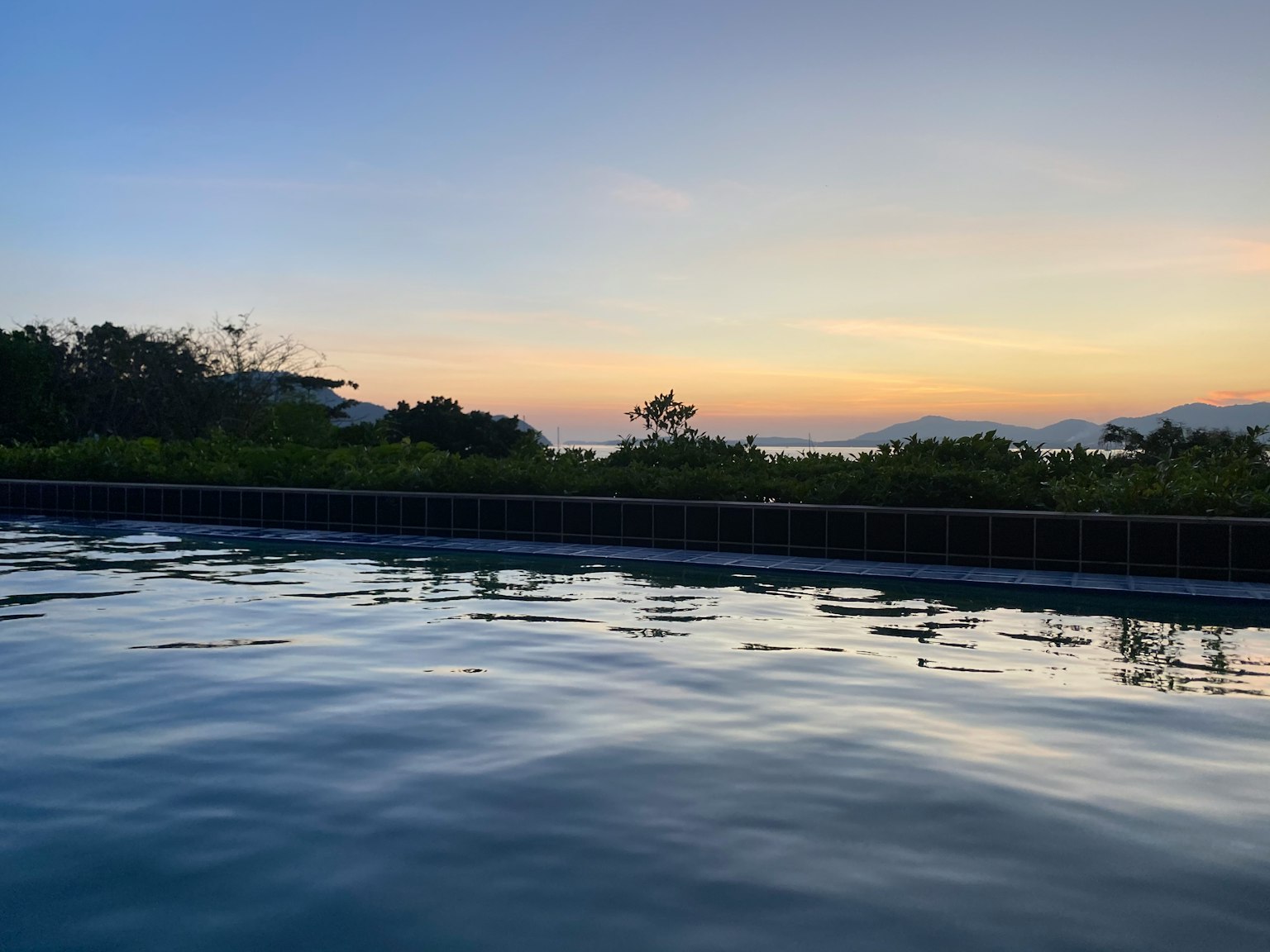 Serene pool scene reflecting the sunset sky and calm water
