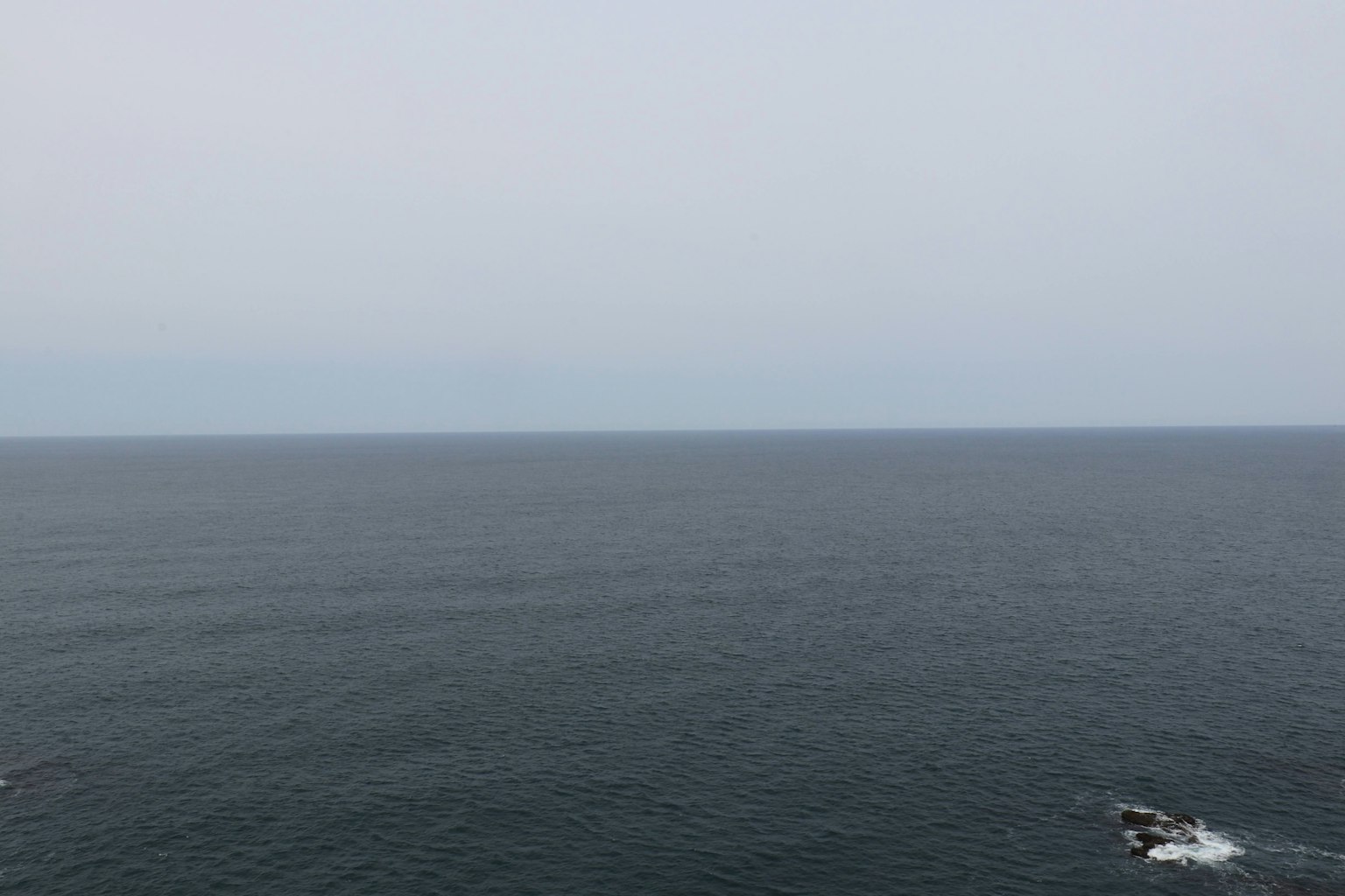 Weites Meer unter einem bewölkten Himmel mit sanften Wellen