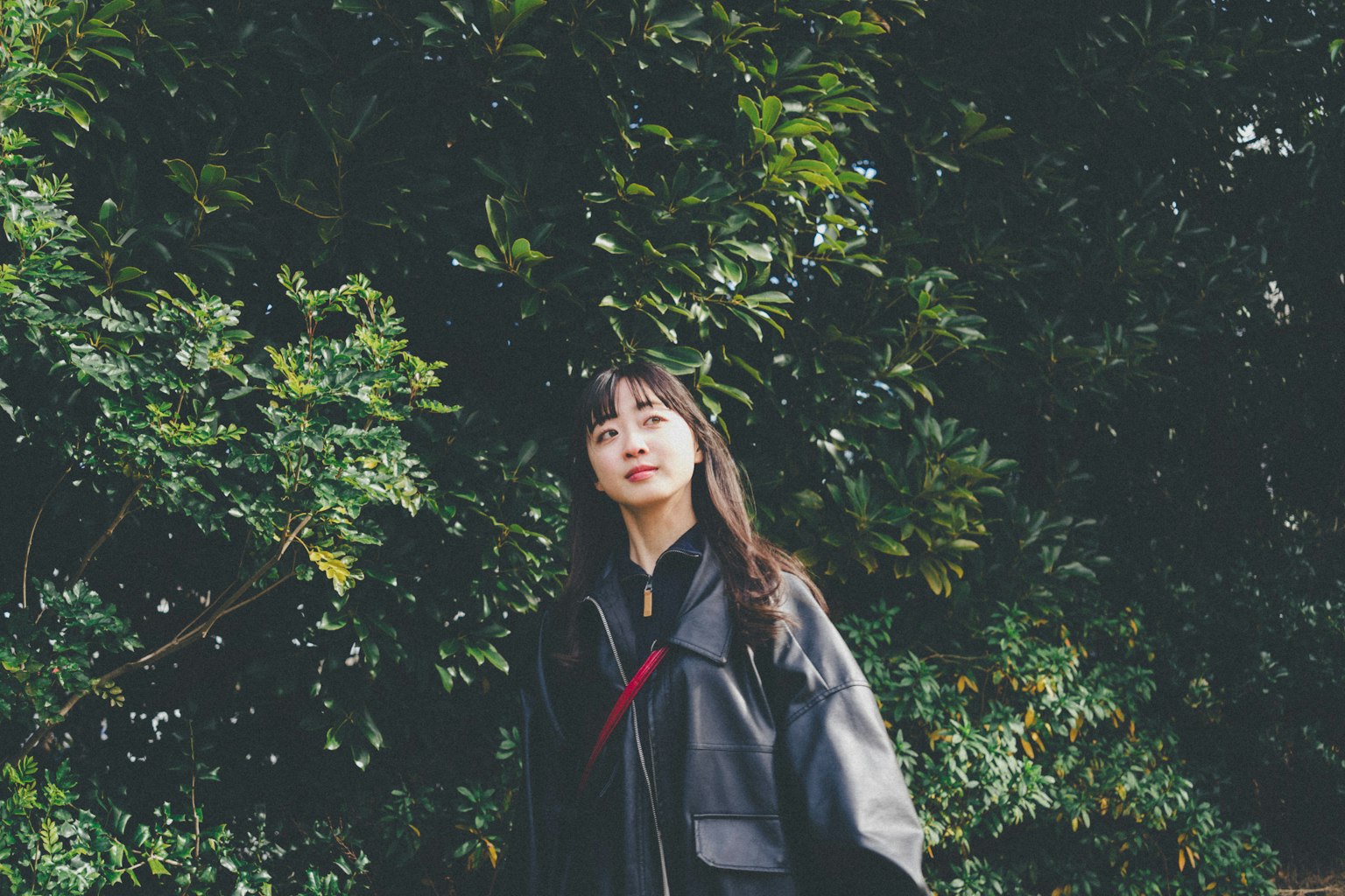 Portrait of a woman standing in front of a green background