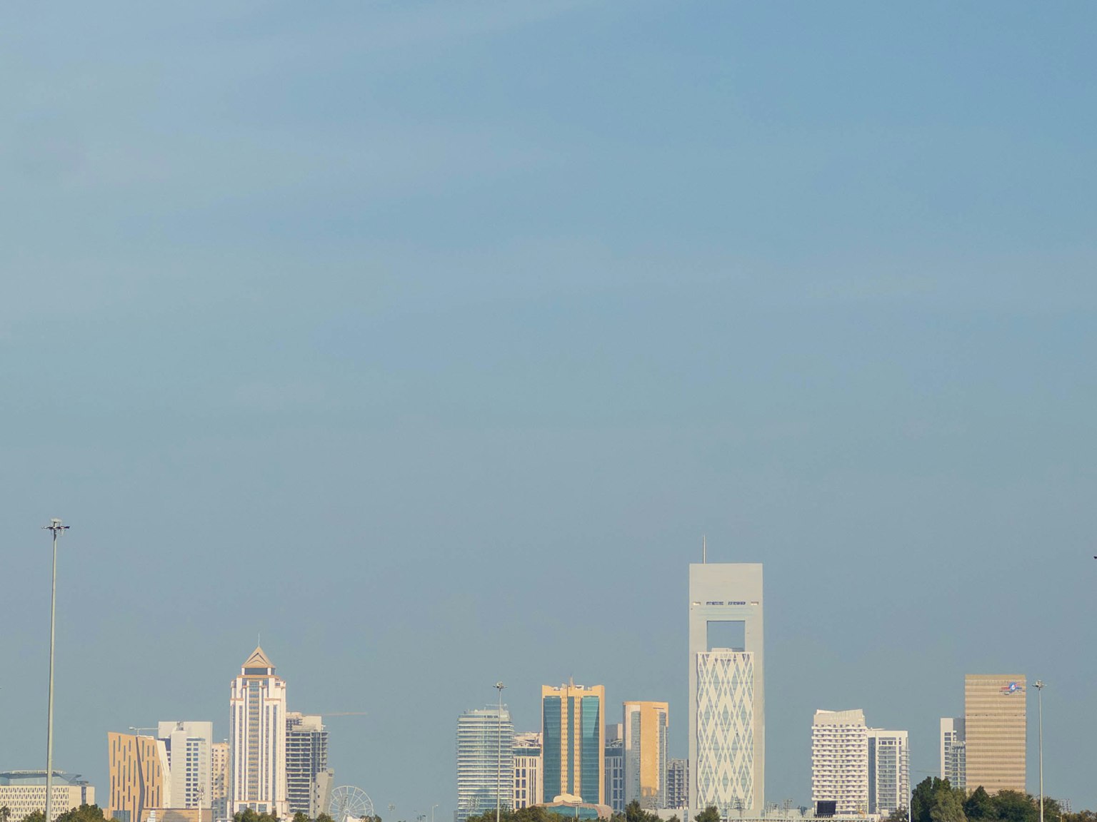 Modern city skyline under blue sky featuring tall buildings