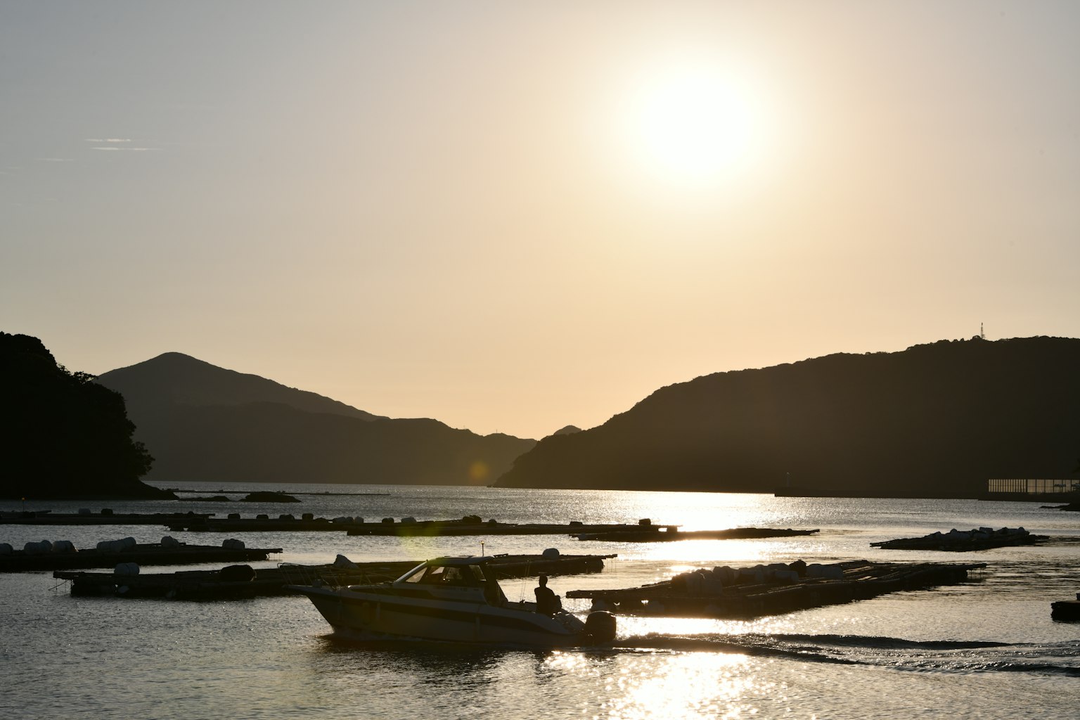 夕阳下的宁静海面和剪影船只