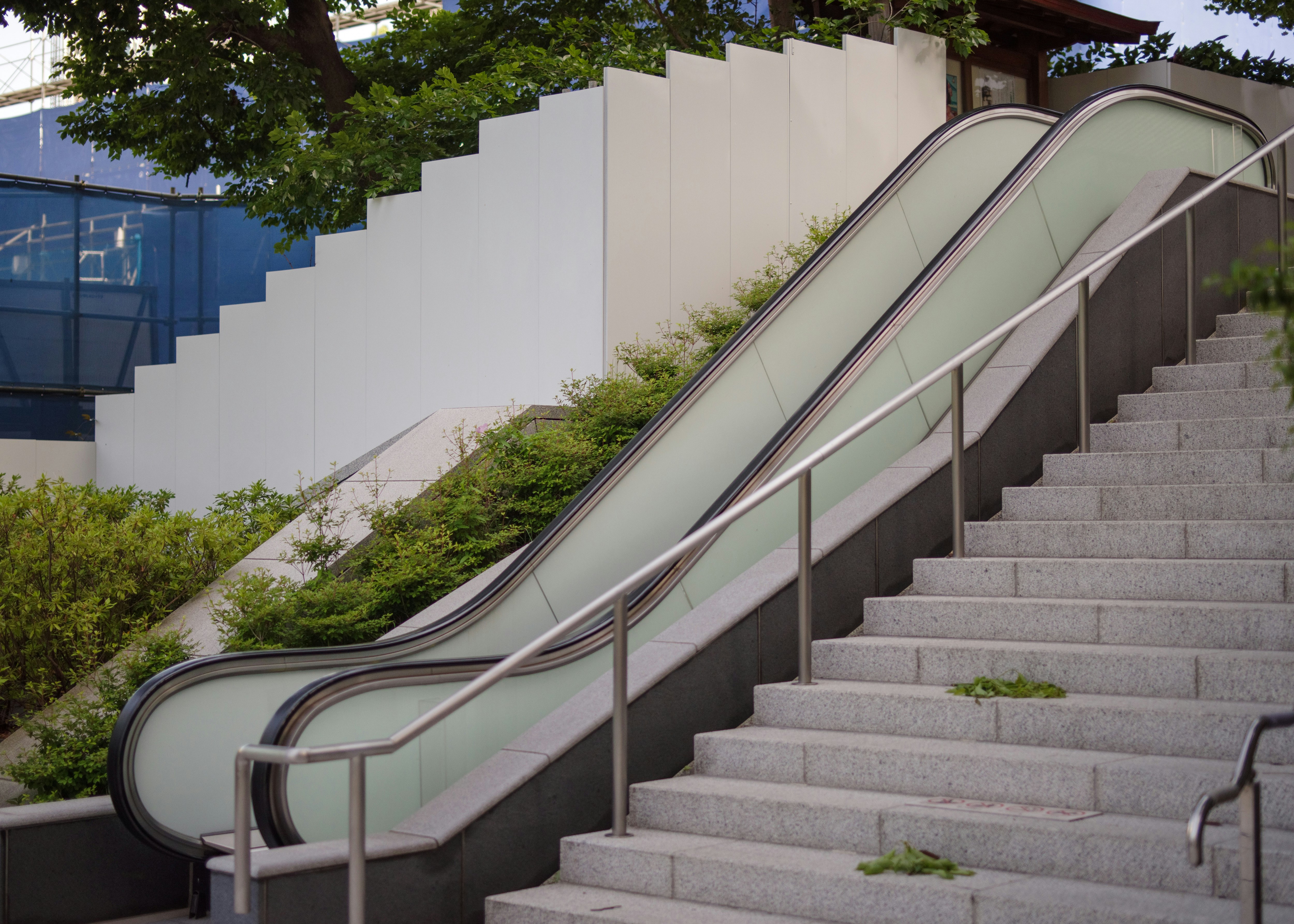 tangga luar ruangan dan moving walkway di pintu masuk gedung