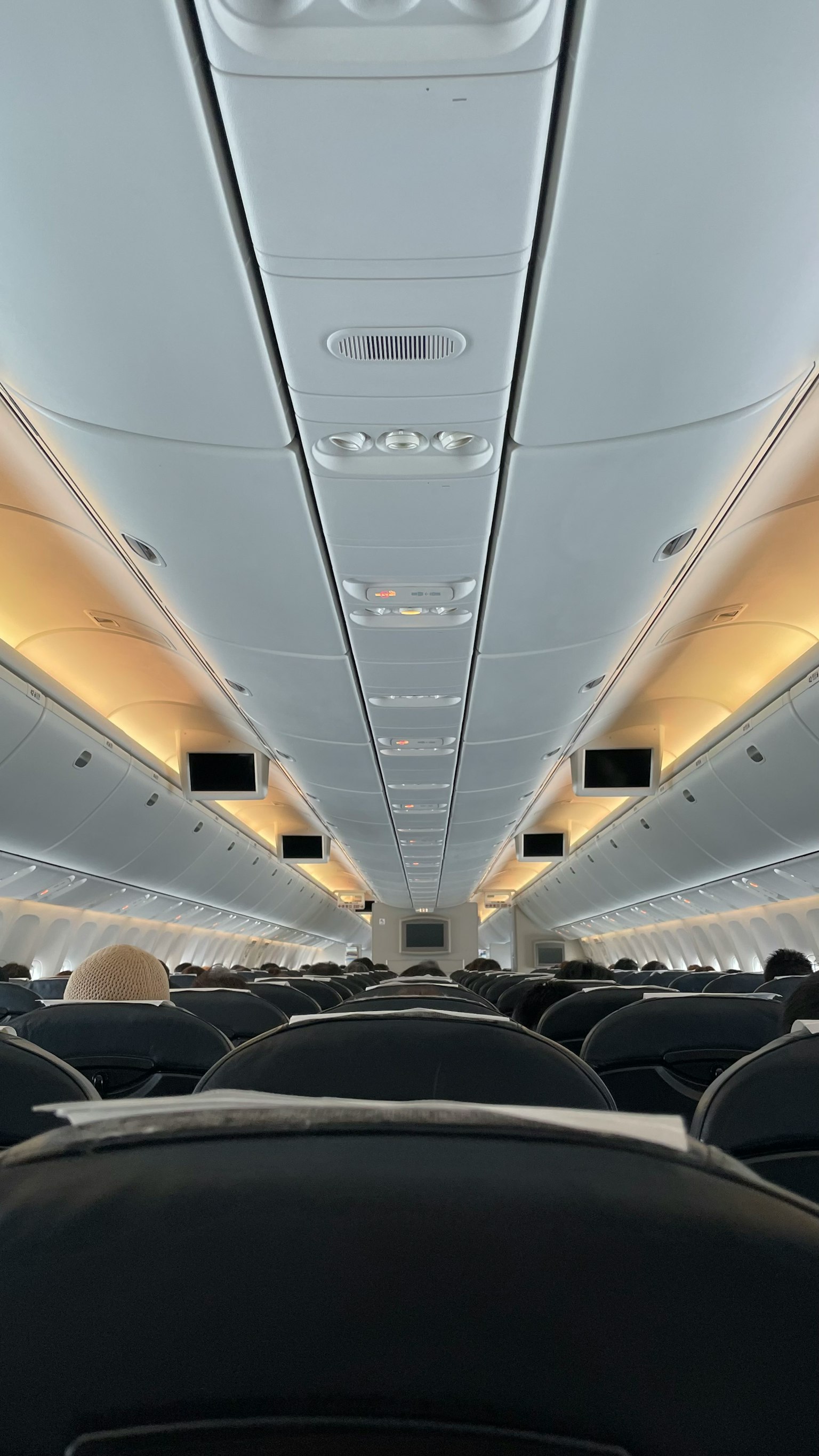 Interior of an airplane showing a long aisle and rows of seats