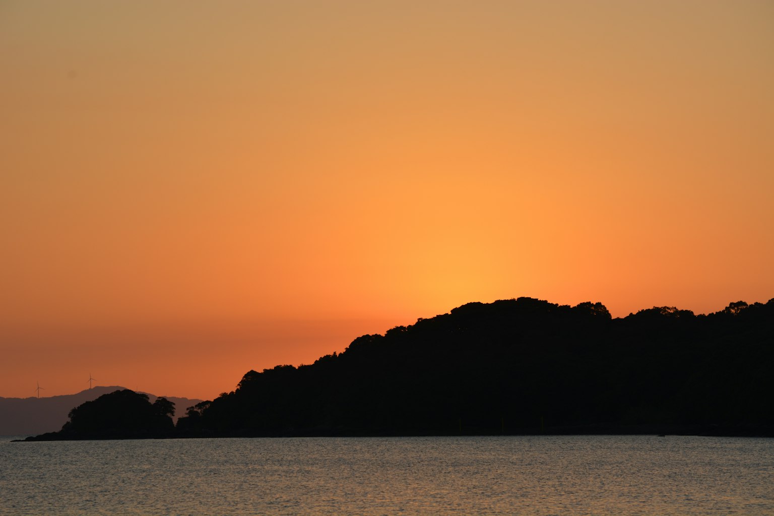 Silhouette einer Küste mit Sonnenuntergang über dem Ozean