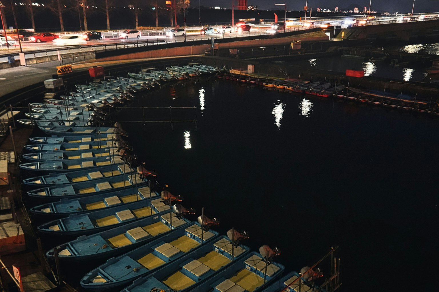 Sekelompok perahu biru berlabuh di pelabuhan di malam hari