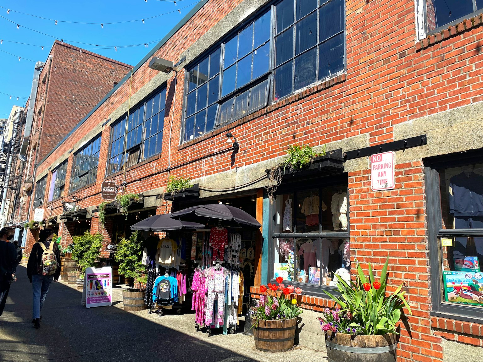 一棟磚造建築外有商店，陽台上裝飾著花卉和植物