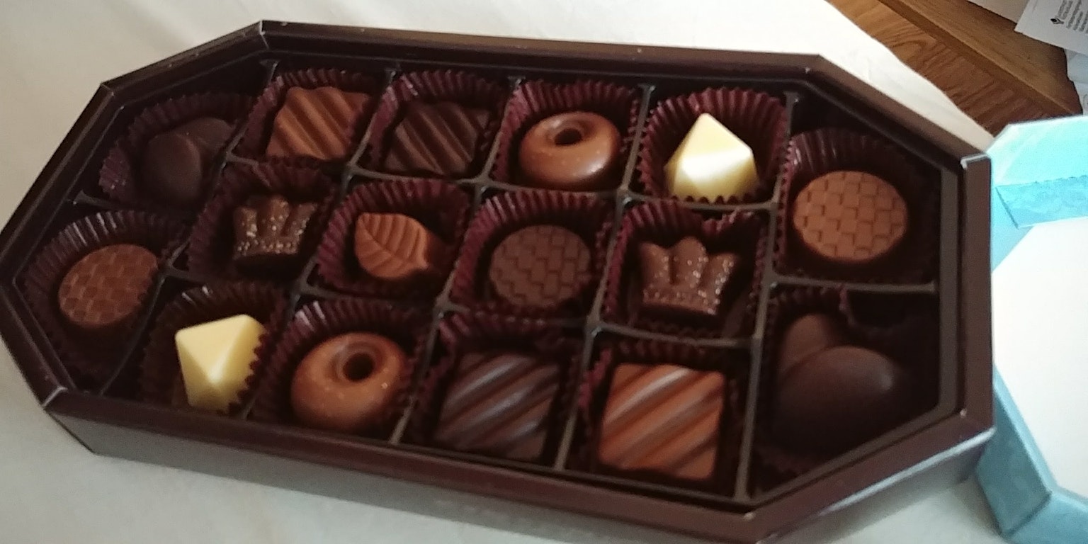 Una scatola di cioccolatini assortiti disposti ordinatamente