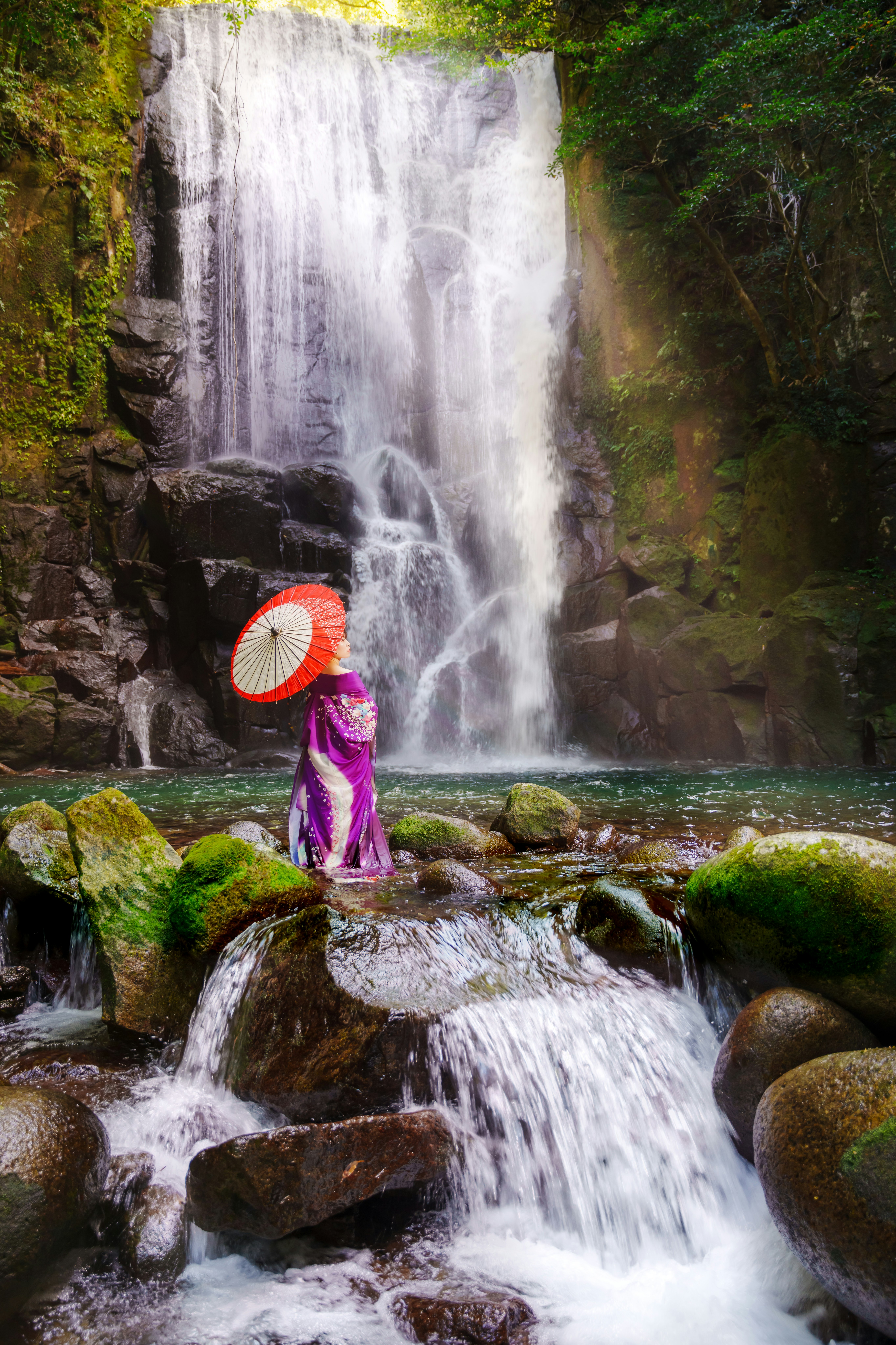 Person im Kimono steht vor dem Wasserfall des Maulbeerbaums