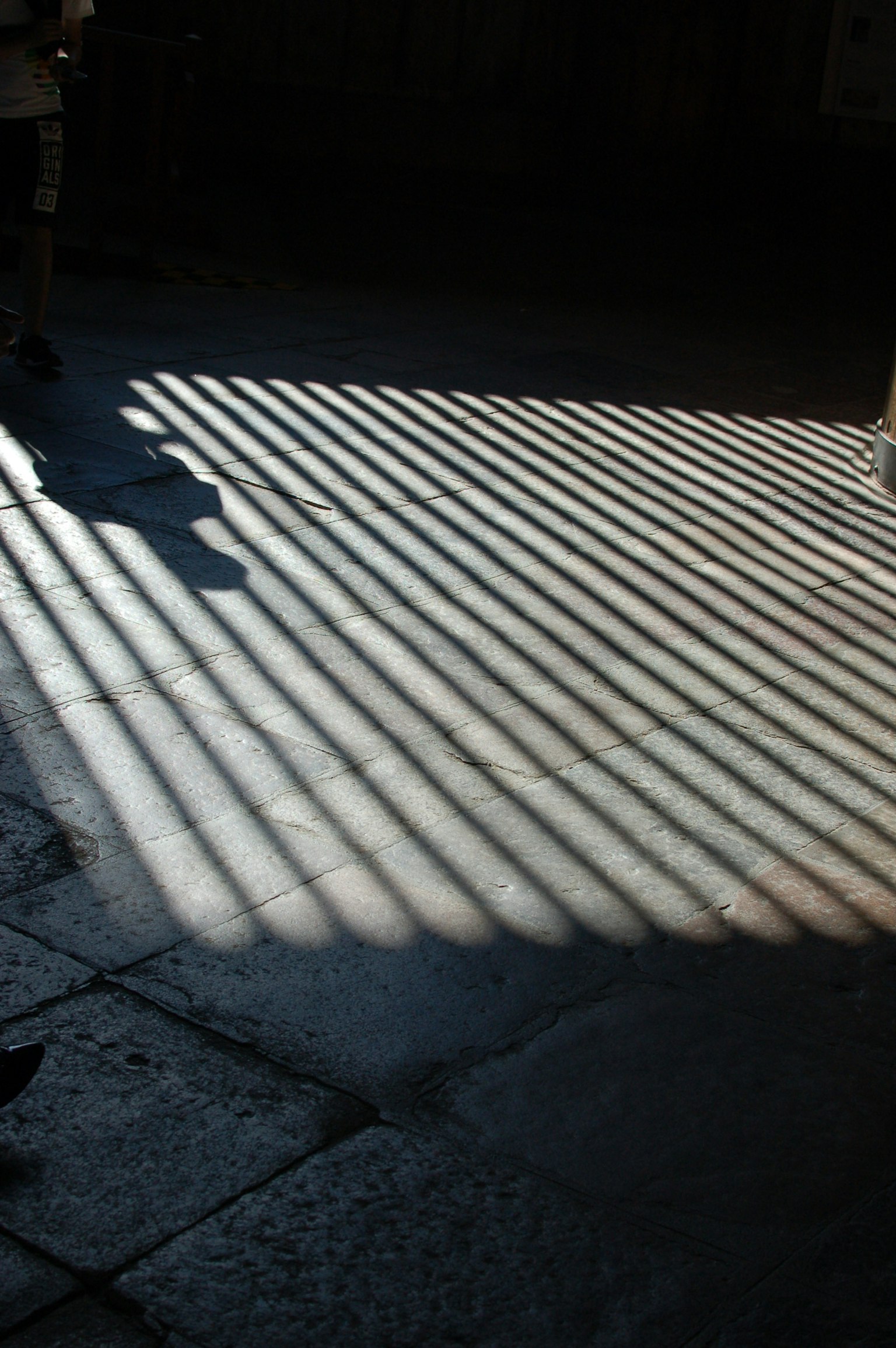 Rayas de luz proyectadas en el suelo creando una sombra con patrón