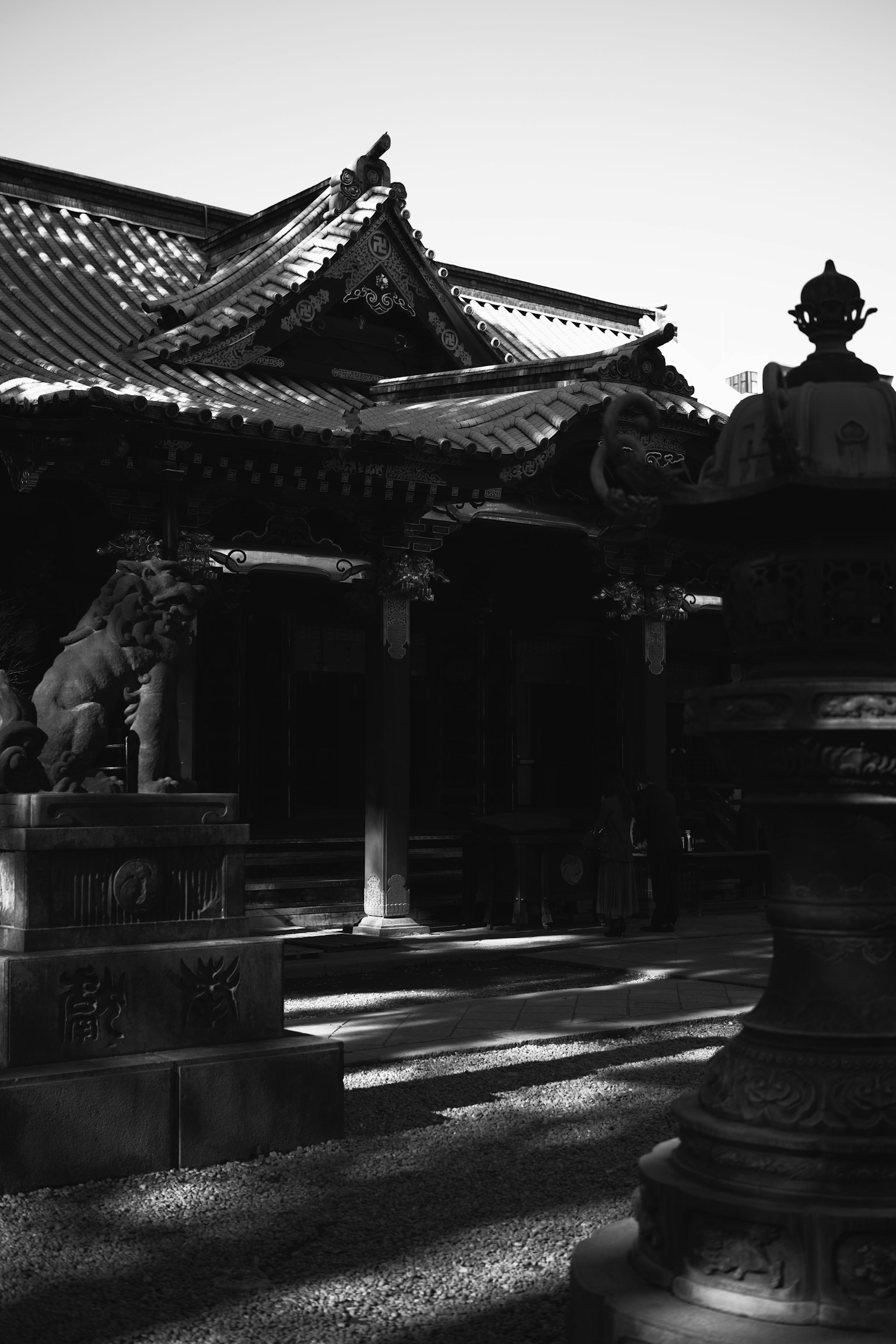 전통 사원 구조와 돌 사자상 및 드라마틱한 그림자