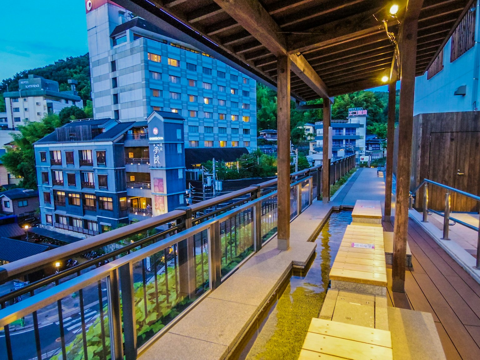 Terrassenbereich mit Fußbad mit Blick auf eine Thermalstadt bei Nacht