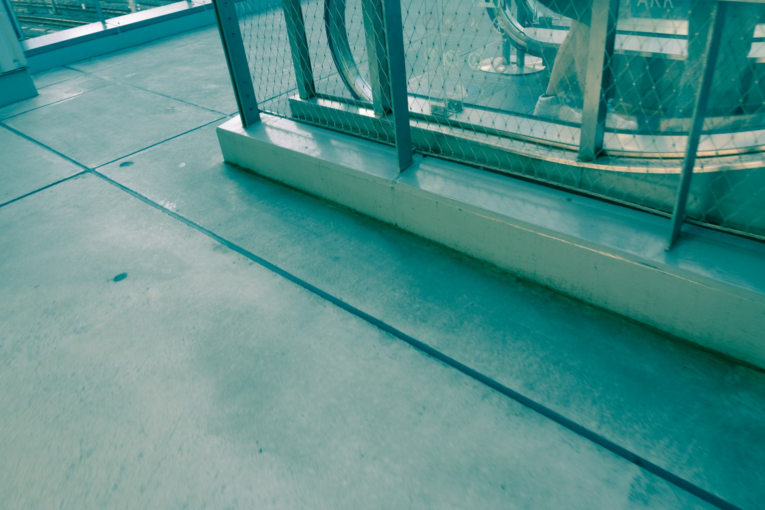 Concrete floor section with transparent fence in the background