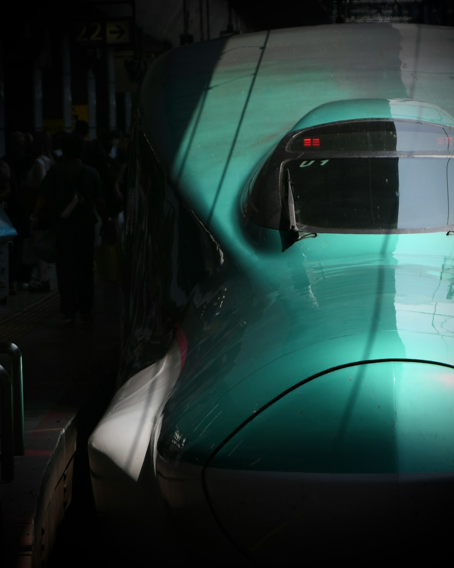 Phần đầu của tàu Shinkansen màu xanh dừng lại tại một ga tối