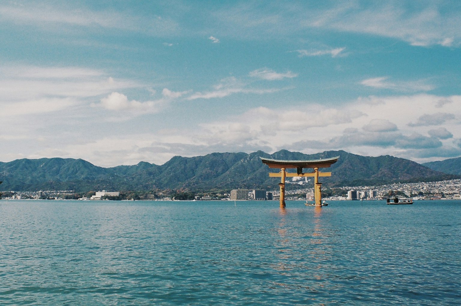 Torii flottant dans la mer avec des montagnes en arrière-plan