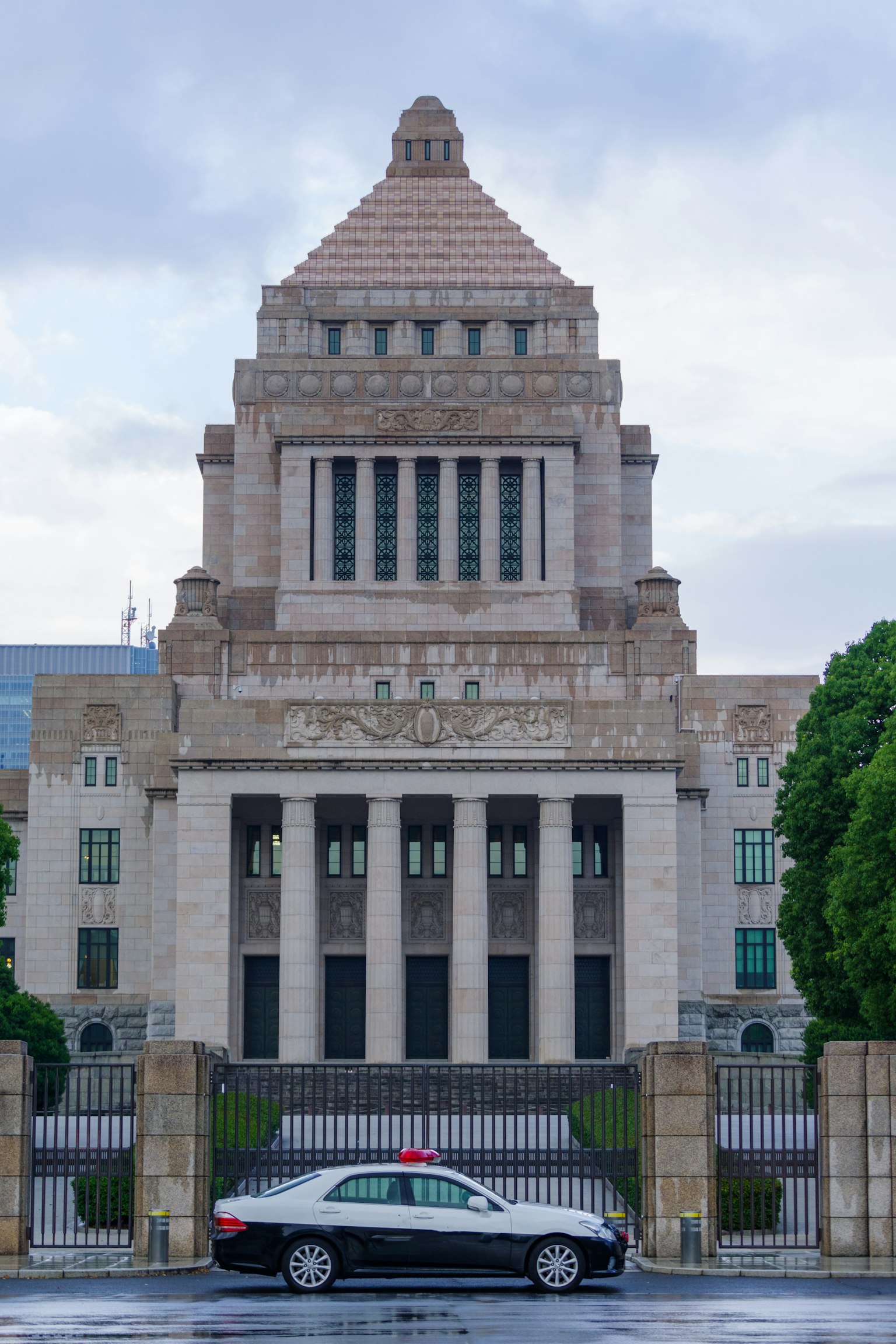 ทัศนียภาพของอาคารรัฐสภาในญี่ปุ่นพร้อมรถยนต์ด้านหน้า