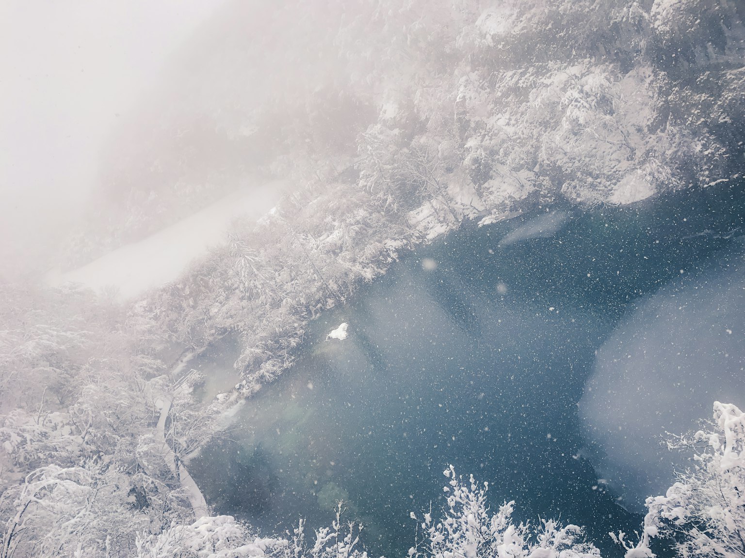 Lac serein recouvert de neige avec une atmosphère brumeuse