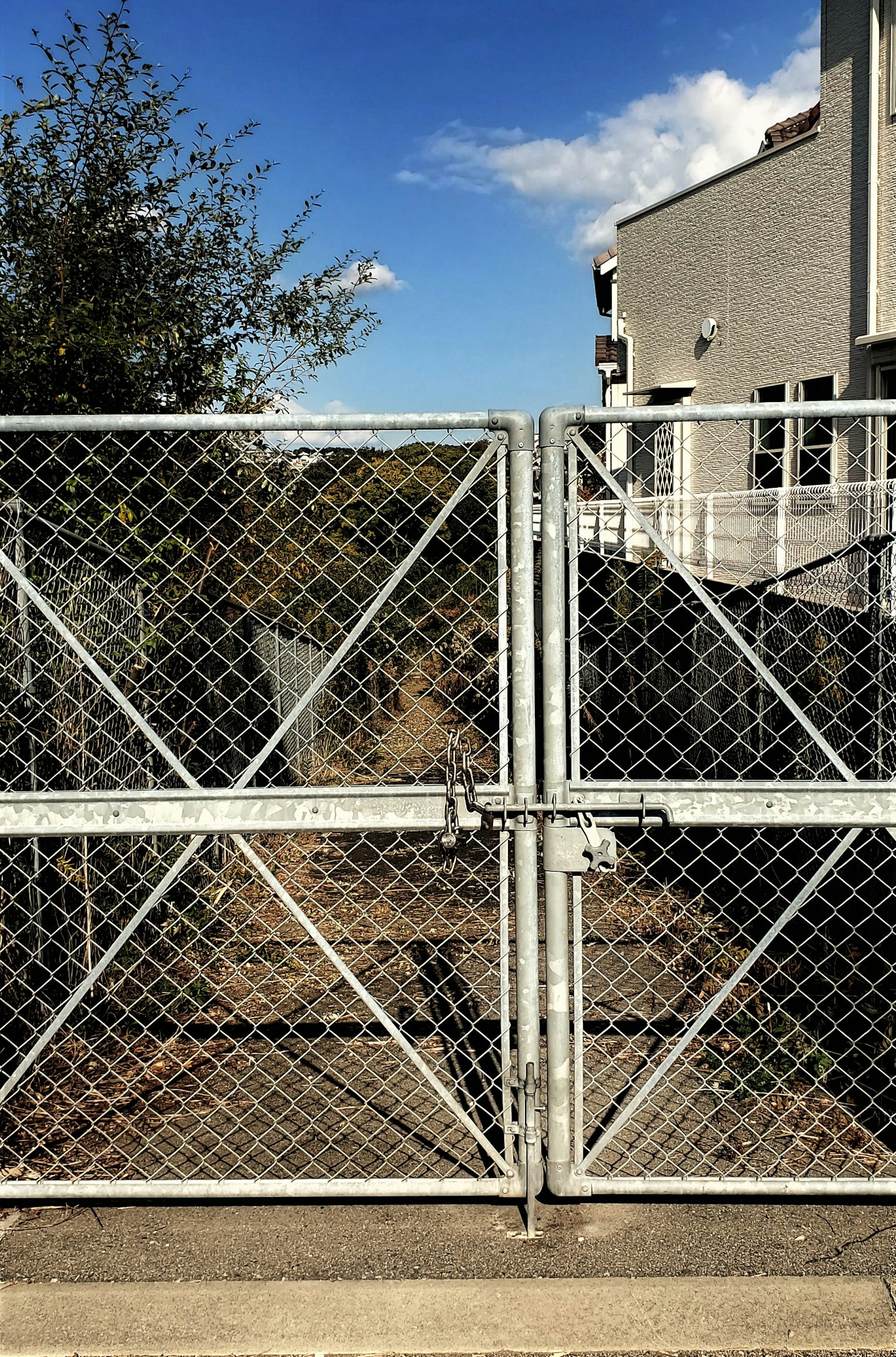 Metal fence gate closed in front of a clear blue sky