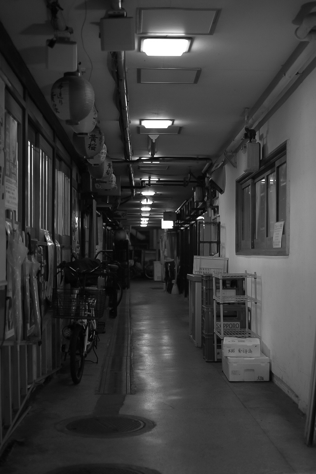 長い廊下に並ぶ自転車と掲示物のある通路