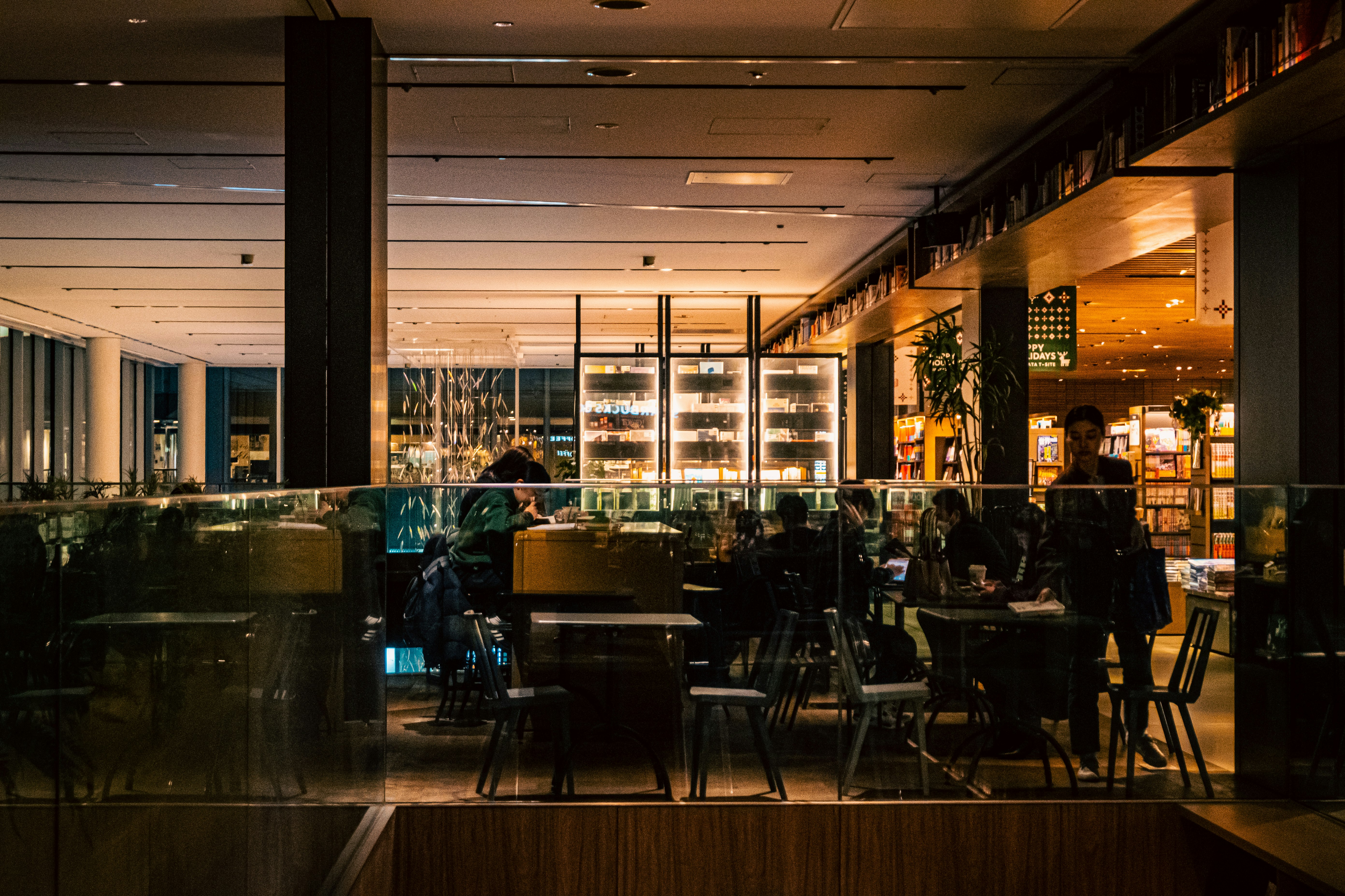 ガラス越しのカフェ店内とカウンターの夜景