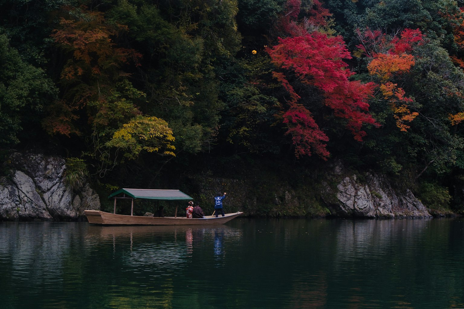 Un lago tranquillo con una piccola barca e foglie autunnali colorate