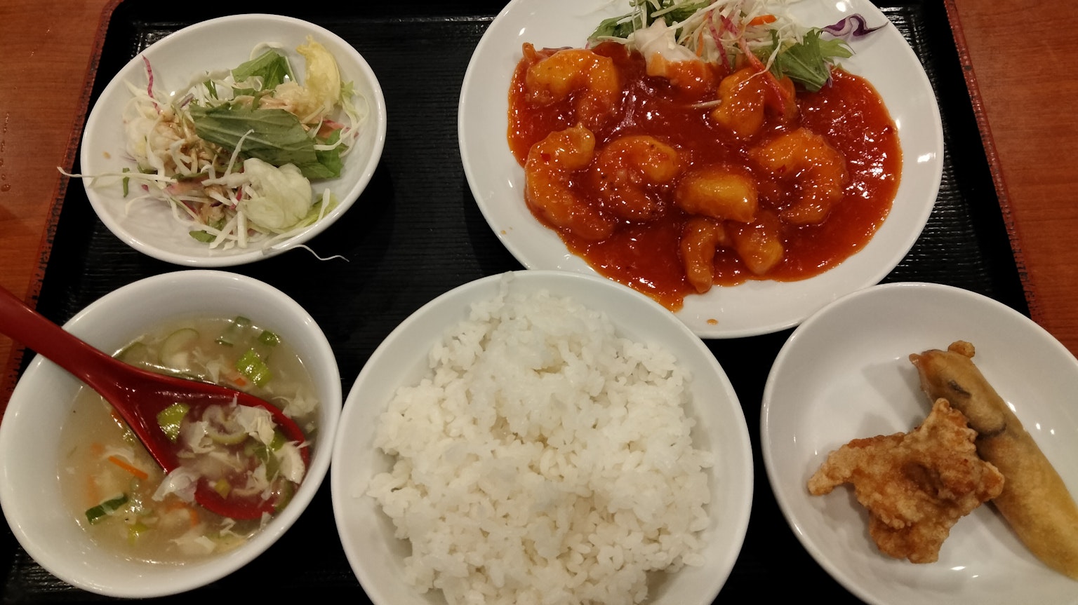 Plate of shrimp in sauce with rice salad and side dishes