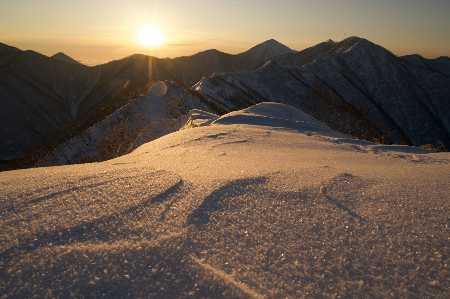 被雪覆盖的山脉景观和升起的太阳